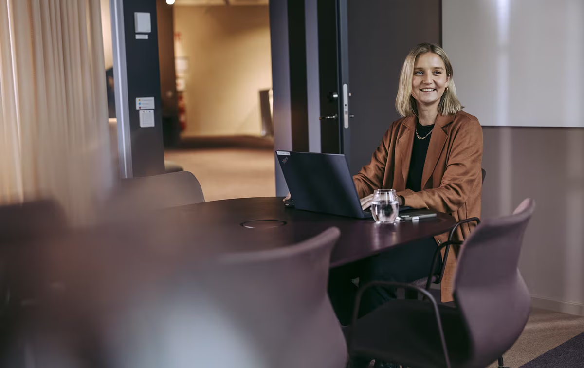 Forøyd dame som jobber på sin laptop